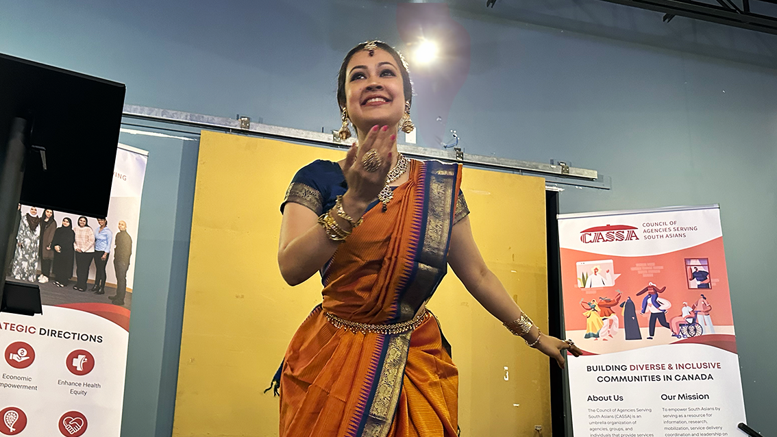 A woman dressed in a sari and dancing