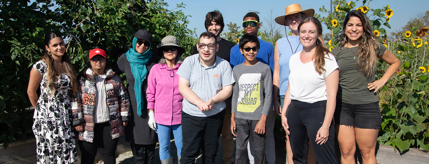 Group of people standing in community garden.