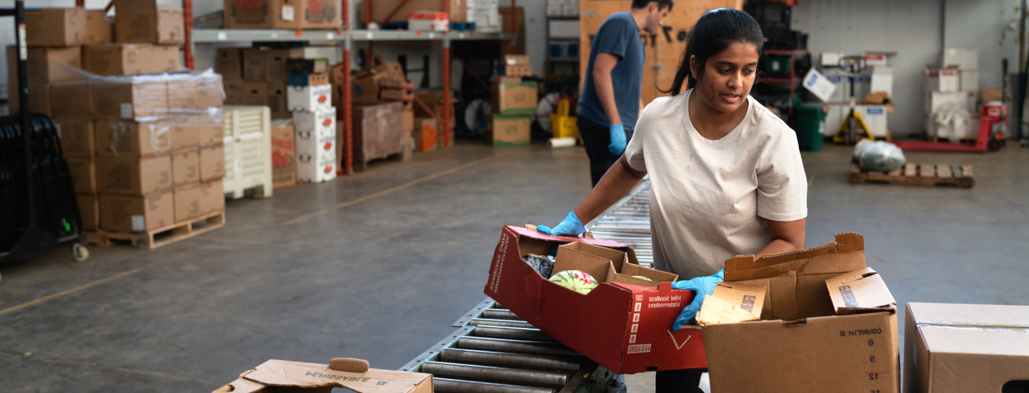 Woman working at food bank loading boxes.