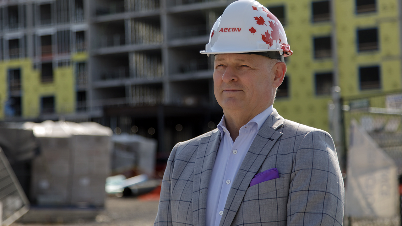 Tim Murphy, executive vice-president and chief strategic affairs officer at Aecon, wears a hard hat and stands in a construction area.