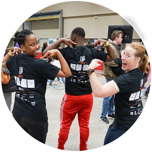 Three people with their backs to the camera showing off their United Way ClimbUP t-shirts with their climb times on the back. 