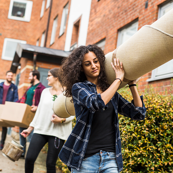 People carrying furniture and boxes out of an apartment.