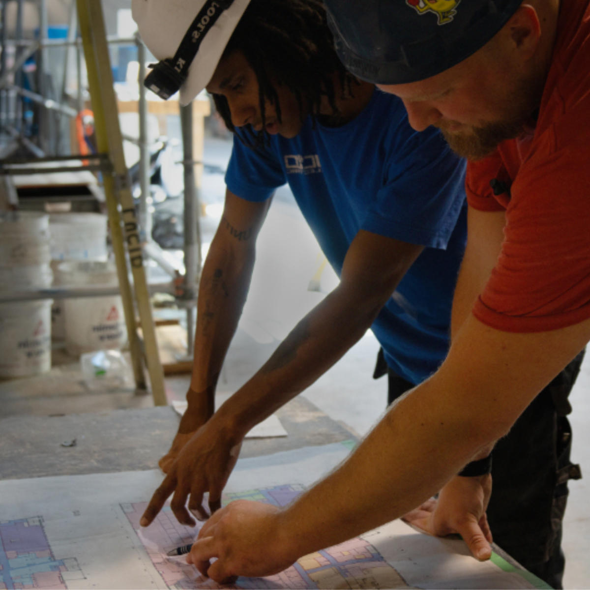 Construction workers reviewing community hub plans.