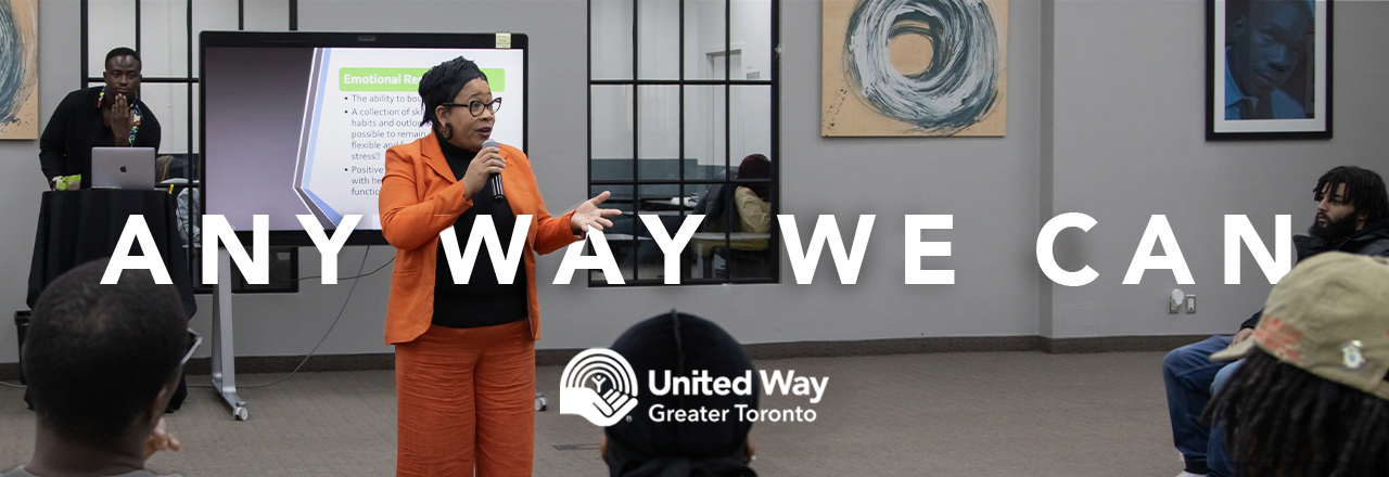 A Black woman presents to a large crowd at CEE Centre for Black Excellence.