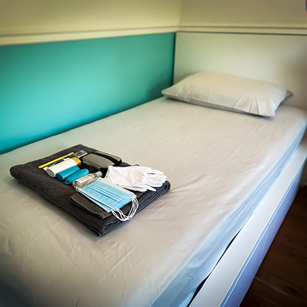 A single bed with a welcome toiletry kit at a shelter. 